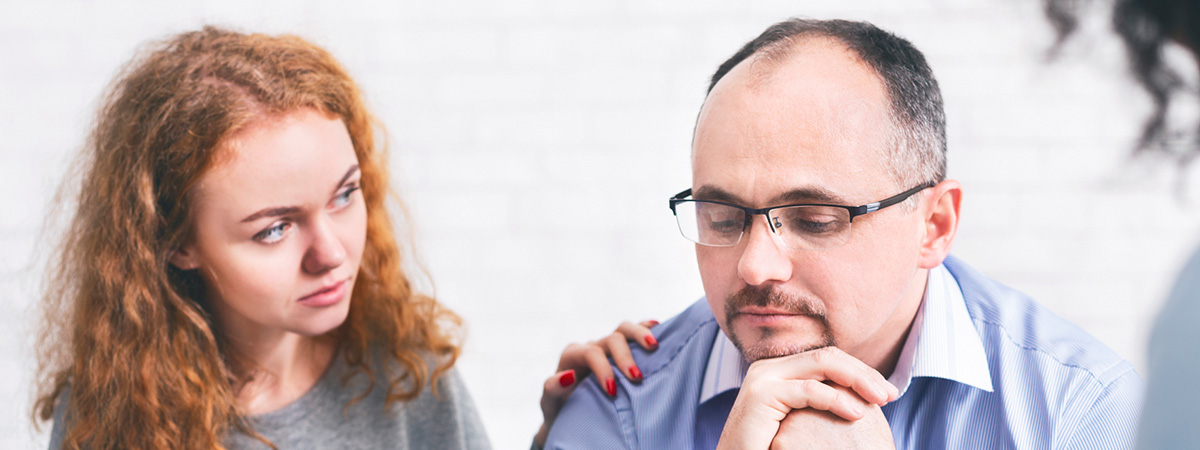  Supportive wife comforting husband with TRD during a meeting with a counselor in Roxbury.